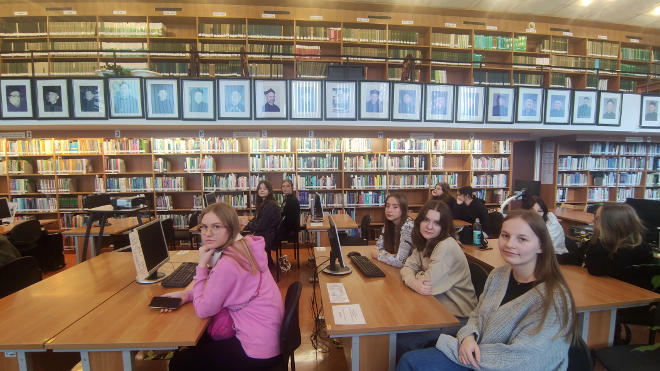 uczniowie siedzą w bibliotece na wykładzie