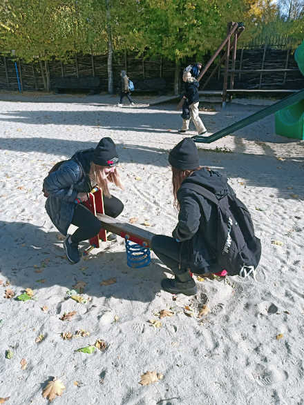 uczniowie na placu zabaw dla dzieci na huśtawkach