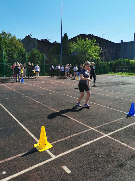 uczniowie na boisku szkolnym biorący udział w wyścigach
