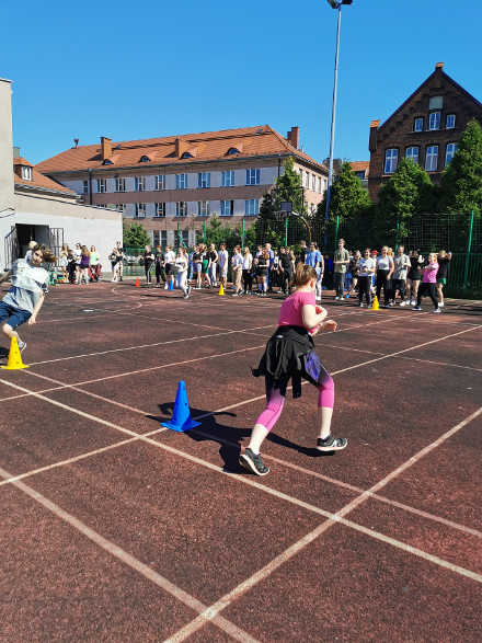 uczniowie na boisku szkolnym biorący udział w wyścigach
