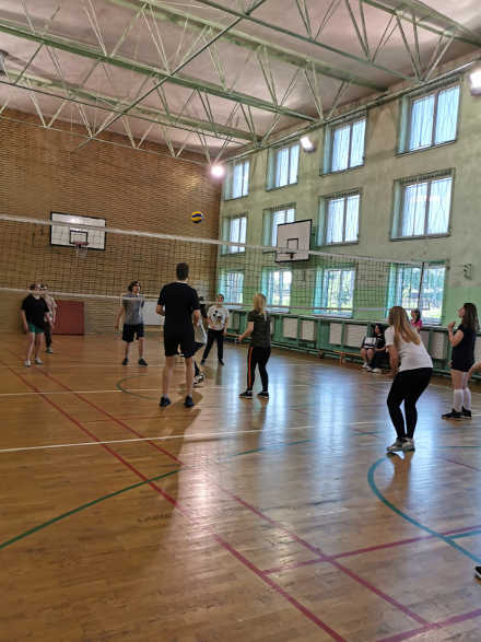 uczniowie na sali gimnastycznej grający w siatkówkę
