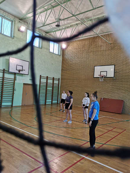 uczniowie na sali gimnastycznej grający w siatkówkę