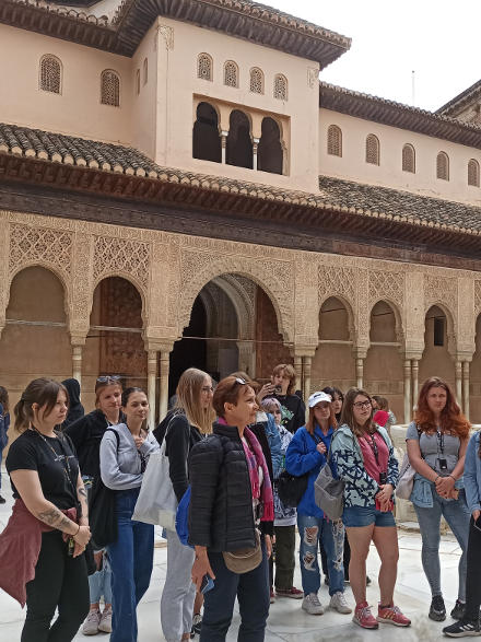 grupa zwiedza Alhambrę – pałac arabski w Grenadzie, na dziedzińcu pałacu uczestnicy wraz z przewodniczką