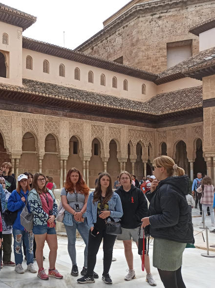 grupa zwiedza Alhambrę – pałac arabski w Grenadzie, na dziedzińcu pałacu uczestnicy wraz z przewodniczką