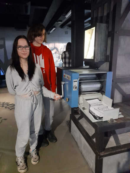 uczniowie przy maszynie do drukowania ulotek