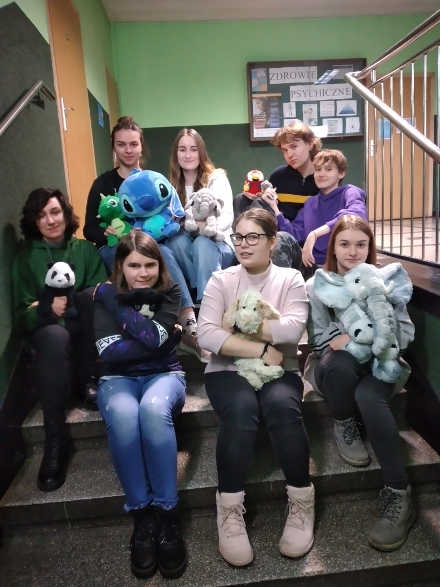 grupa uczniów z zabawkami pluszowymi