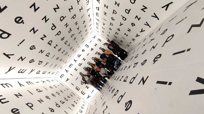 uczennice wewnątrz instalacji artystycznej w postaci sześcianu z literami