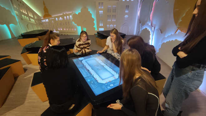 uczennice grają w grę interaktywna w muzeum